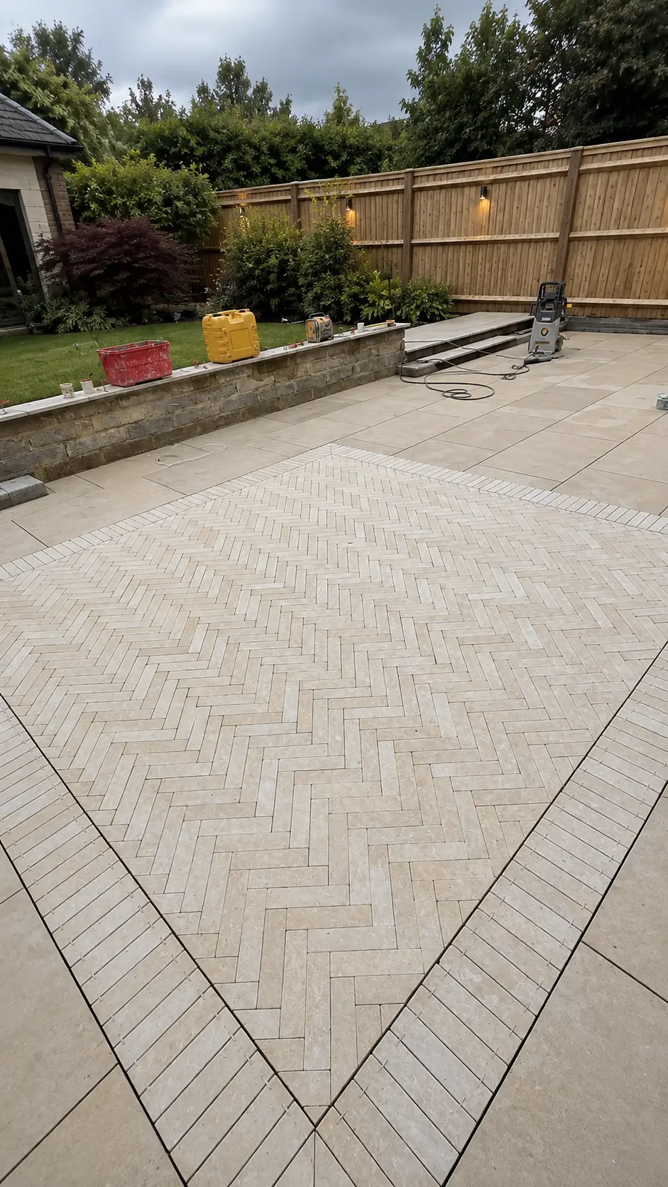 Large herringbone panel in Mint sandstone cobbles, framed by paving on a completed project