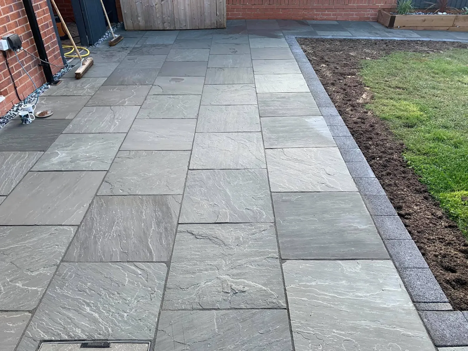 Kandla Grey sandstone paving along a lawn